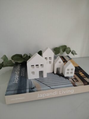 New Page Set of 4 white handmade concrete decorative houses, on a book.